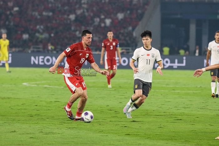 Thom Haye (kiri) sedang menguasai bola dan dibayangi Wang Yudong (kanan)