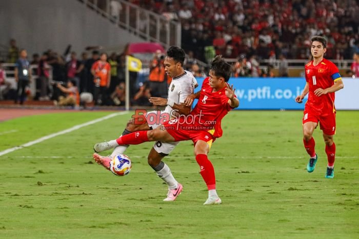 Robi Darwis (kiri) sedang berebut bola dengan Van Truong Nguyen (kanan)